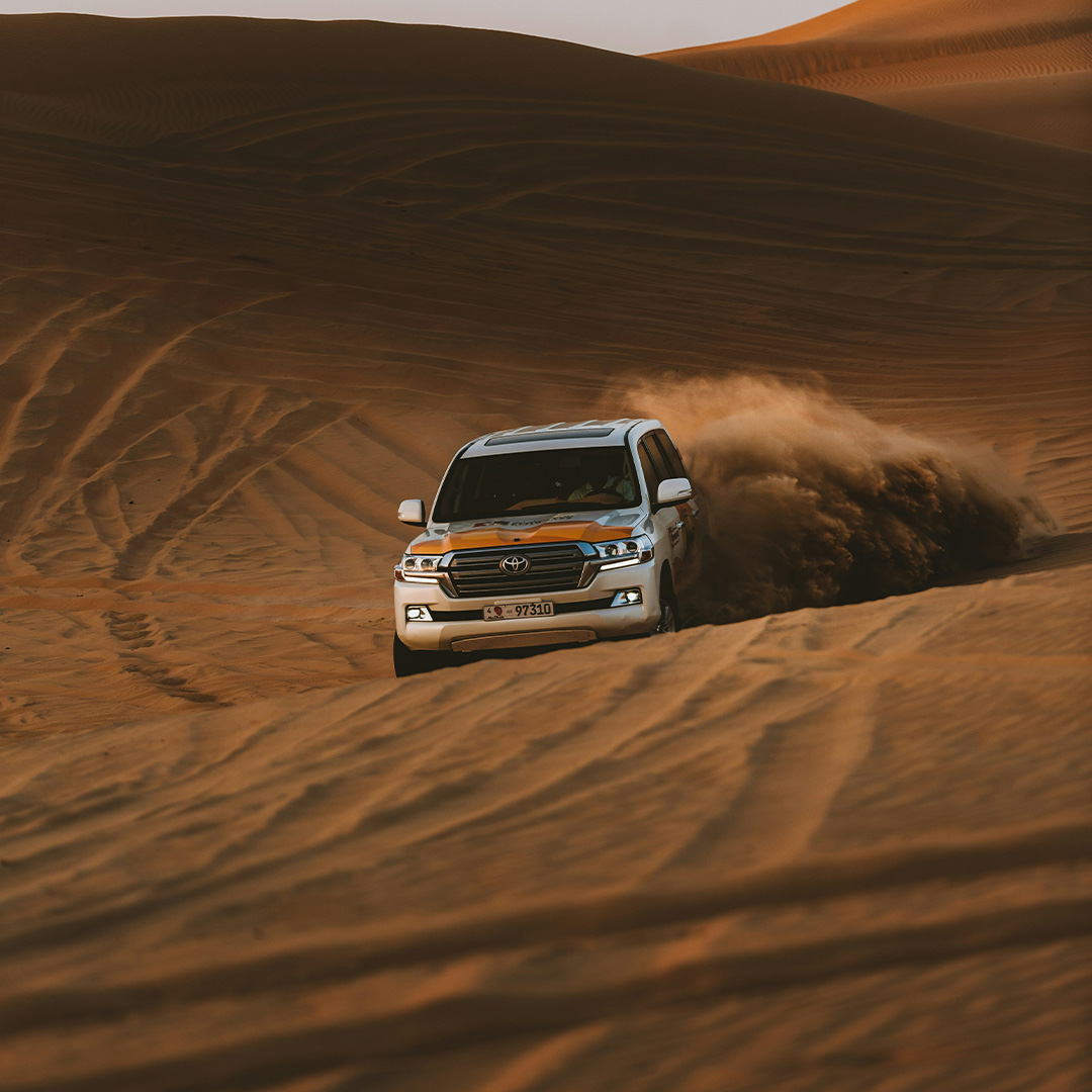 A Land Cruiser is dune bashing on desert safari in Dubai